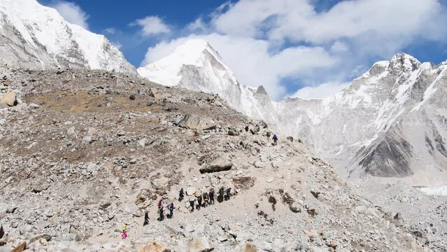 .Group of trekkers with guides trek final push to EBC viewpoint in Sagarmatha national park. EBC trekking. Everest base camp trekking in fall, autumn in sunny weather.