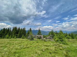Fairytale landscape against green mountains and dramatic sky.