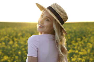 Portrait of happy young woman in field on spring day