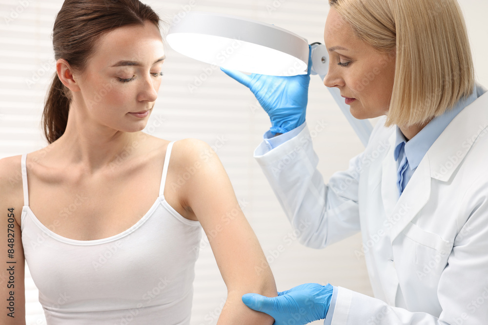 Canvas Prints Dermatologist examining patient under lamp in clinic