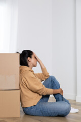 Young woman takes a break while packing her things into boxes to move into her new house. Woman overwhelmed by the move. She is a homeowner, mortgage concept. New home, new life