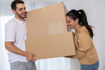 Happy couple packing their stuff to move into their new owned house. They are homeowners, mortgage concept. New home, new life