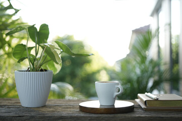 small white cup on wooden tray and notebook and plant pot balcony outdoor chilling