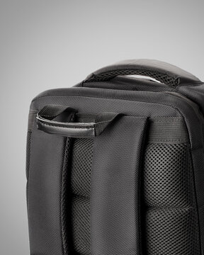 Sturdy black backpack designed with multiple zippered compartments and adjustable straps against grey background. Concept of  convenient stylish accessory for business trips and travel