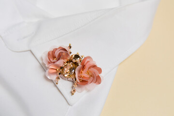 Decorative handmade brooch in the shape of a beetle on the collar of a white shirt