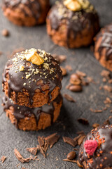 Round chocolate cakes. Decorated with candied raspberries. Dark background.