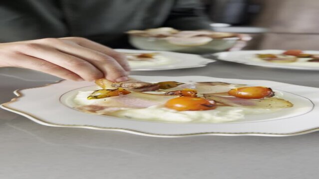 Preparing stracciatella di bufala with roasted tomatoes and bacon flambe 