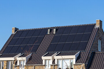 Fototapeta premium Solar panels on the roofs of houses on a sunny day 