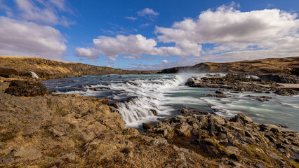 Fototapeta premium Wasserfall auf Island vor bewölktem Himmel