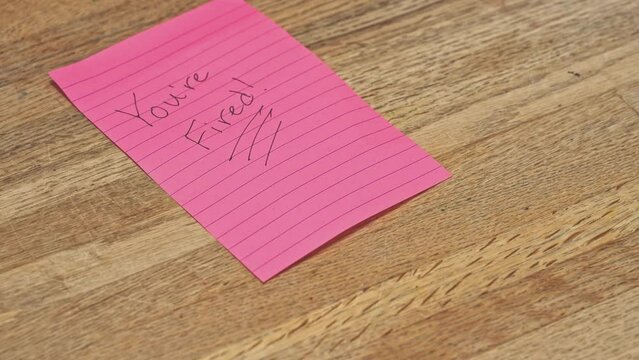 Written note pad, "You're Fired" "I quit" quitting, lay-off job loss, unemployment, disciplinary action, HR Human resources, toxic work environment, 4K