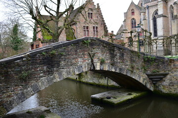 Fototapeta premium The small stone and brick Bonifacius bridge arching over a small canal in the medieval city centre of Bruges