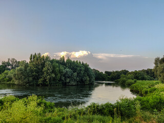 Landscape with river, trees and blue sky