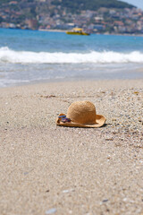Straw hat, sun glasses on a beach of sea.