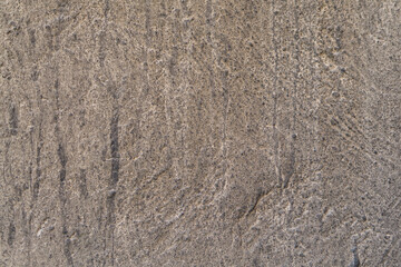 The old greasy dusty rough background of the wall of the building is grayish brown. Creates the impression of desolation, aging, abandoned dwelling, abandoned living space, blank for text.