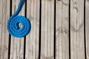 Obraz premium Blue mooring line on wooden deck