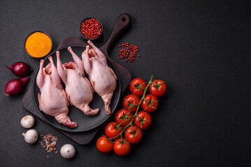 Whole raw quails with salt, spices and herbs on a dark concrete background