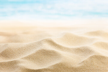background of beach sand in the foreground and out of focus sea in the background