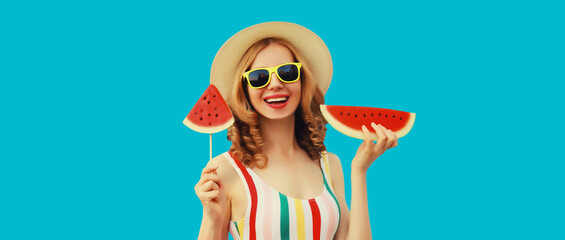Summer portrait of happy young woman with lollipop watermelon wearing straw hat on blue background
