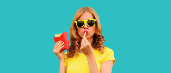 Portrait of stylish young woman eating french fries, fried potatoes fast food