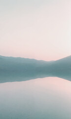 This is a picture of a calm lake at sunset with a pink sky and gray mountains in the distance.

