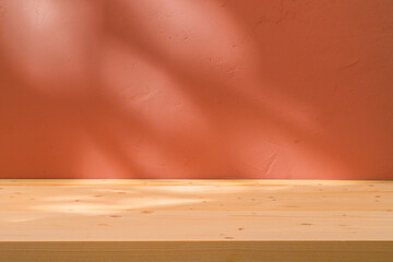 Table with coral pink wall and sun light reflections. Food, product or cosmetic background.	