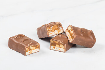 Vegan bar. Nougat, caramel with peanuts, in milk chocolate. In the section.  Close-up