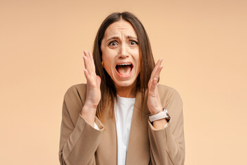 Portrait of attractive fury aggressive woman wearing in a jacket screaming, isolated