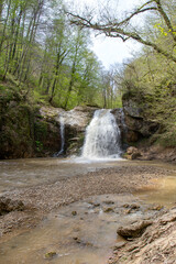 Obraz premium the beginning of summer mountains, waterfall, the sources of the mountain river walking along the canyon , hiking trails and recreation in the mountains.