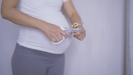 A Portrait of Asian pregnant woman smoking cigarette. Having a baby. Family people lifestyle. Mom...