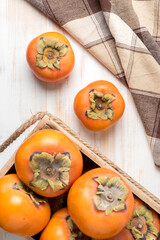 Delicious fresh persimmon fruits on wooden table.