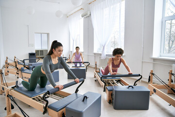 Diverse women engaging in a pilates class, focusing on strength and flexibility exercises.