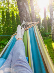 Hammock Haven. A first-person view of a relaxing moment on a vibrant hammock, surrounded by the tranquility of a sunlit forest.