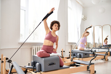 Alluring women engage in a pilates class, focusing on flexibility and core strength.
