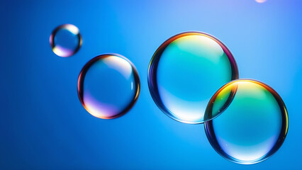 Abstract composition - large transparent soap rainbow bubbles on a bright blue background and a space for copy