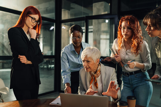Nervous boss criticizing her female team while looking at the laptop.