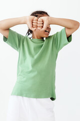 Stressed woman in stylish outfit covering her face with hands in trendy urban setting