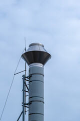 silver steel chimney against a cloudy sky