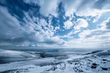 Panoramic view of the Scottish Valleys in winter, with snowcovered hills under a deep blue sky. The photo captures the vastness and beauty of these rugged landscapes