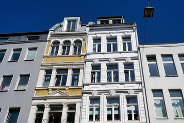 Fototapeta premium beautifully restored and decorated narrow old town houses flanked by unadorned facades in the Friesenviertel district of Cologne