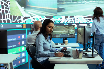 Indian woman employee locating delivery truck drivers via satellite map, sending gps coordinates...