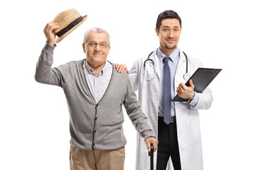 Male doctor posing with an elderly male patient greeting with a hat