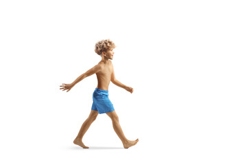 Boy walking in swimming shorts
