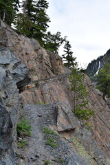 Obraz premium The rocky Mineral Creek Trail near Bear Creek Falls running along the steep mountainside edge