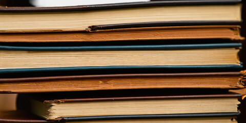 Stacked old books. Yellow page texture of antique books. Hardcover close up.
