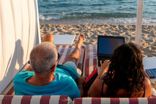 A married couple lying on a daybed. Business and summer vacation