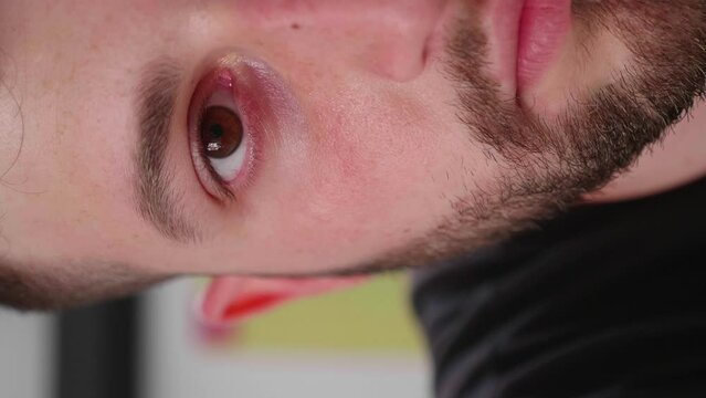 Vertical close-up of half face, eyes closed then opening