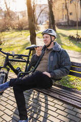 Man Sitting on a City Park Bench Using Cell Phone