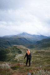 Frau rennt von der Kamera abgewandt frei und wild in die norwegischen Berge