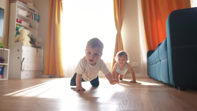First steps. baby is crawling on the floor of an indoors bathroom. Cute kid infant family dream concept. group of baby are crawling around and playing. A group of baby are fun playing and crawling.