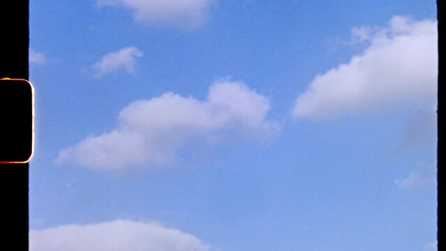 Clear blue synny lightness sky with nice white clouds shooted on 8mm film camera